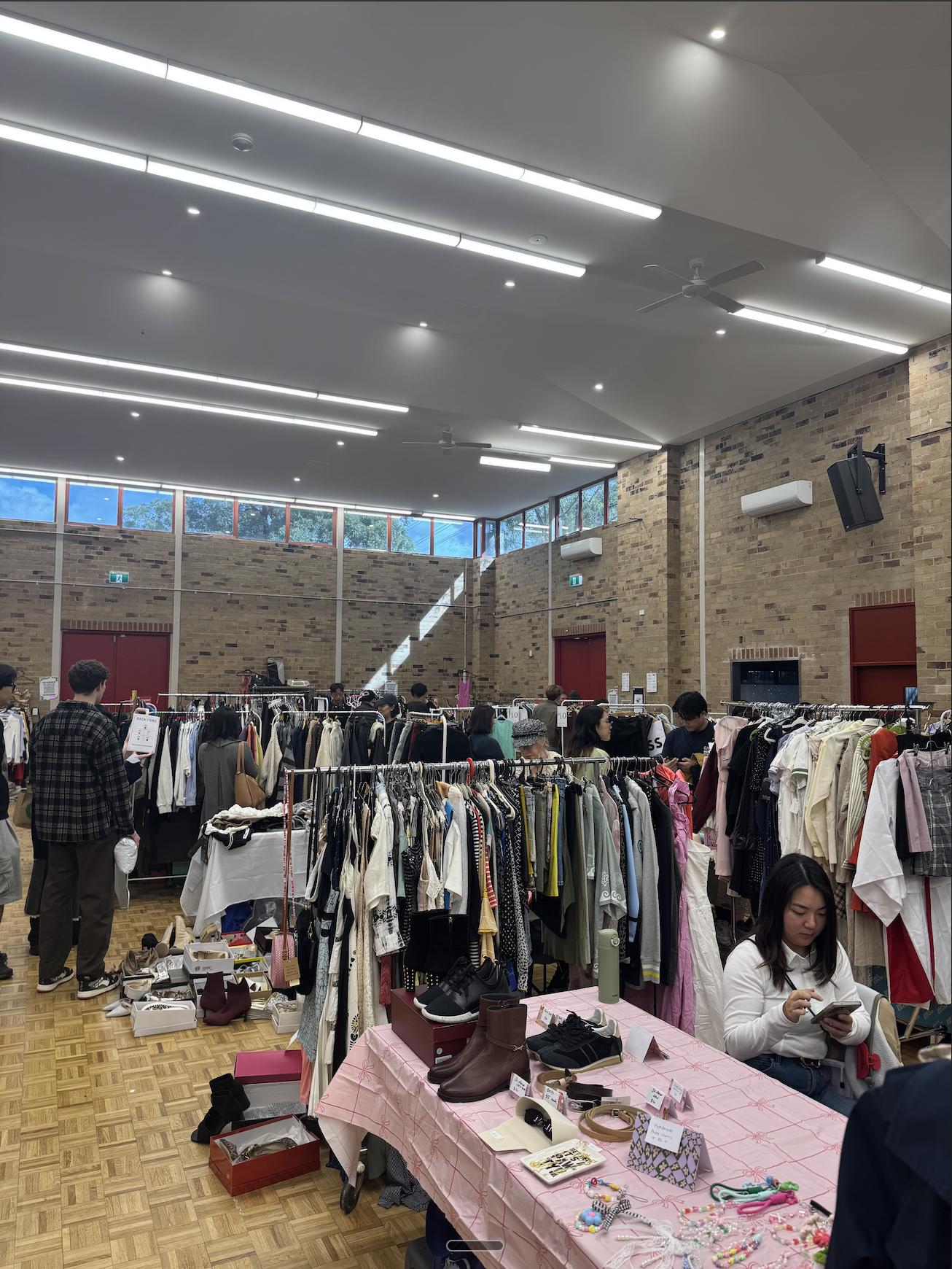 Indoor market with clothing racks and shoppers